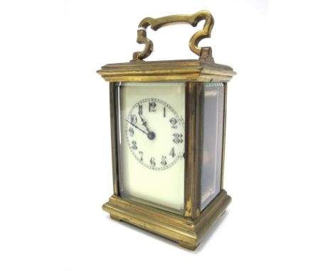 An Early XX Century Brass Cased Carriage Clock, the cream enamel dial with Arabic numerals, fluted columns and bevelled glass