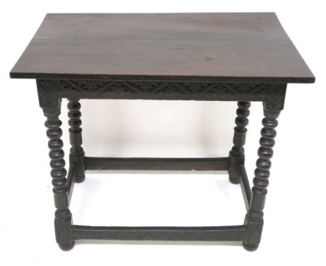 A 17TH CENTURY OAK SIDE TABLE the rectangular top above carved foliate frieze and on bobbin turned legs, joined by stretchers