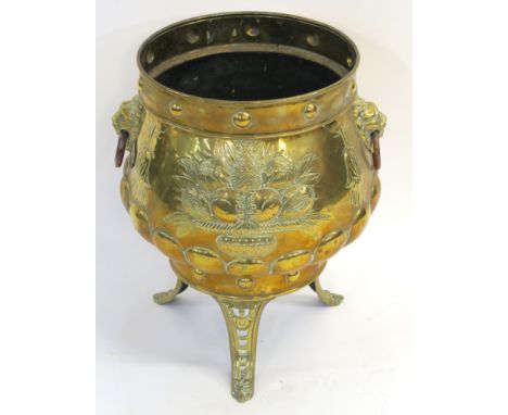 A DUTCH BRASS PLANTER embossed with vases of fruit, flanked by lion ring mask handles and set on three splayed legs, 52cm hig