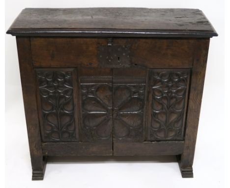 A 16TH CENTURY AND LATER OAK LIVERY CUPBOARD the overhanging moulded top above a pair of heavily carved doors, decorated with