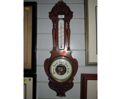A wall mounted barometer with enamel dial