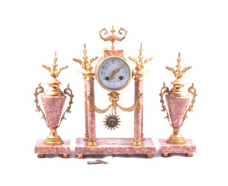 French gilt metal and rouge marble three-piece clock garniture, the portico clock case surmounted by an urn, enamelled dial, 