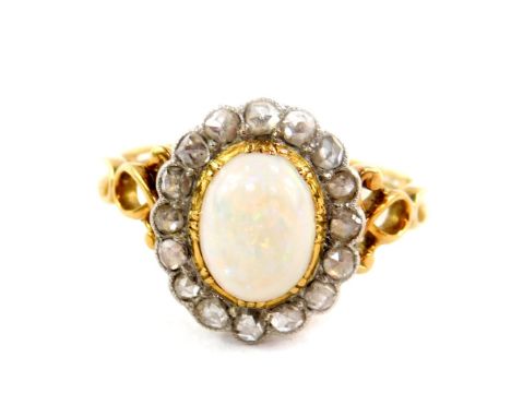 An opal and diamond ring, set in yellow metal, the cabachon opal set in a surround of 16 old cut diamonds, approx 2/3cts, siz