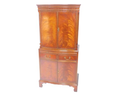 A Reprodux Georgian style mahogany cocktail cabinet,  the outswept pediment over a pair of doors enclosing a single shelf, ab