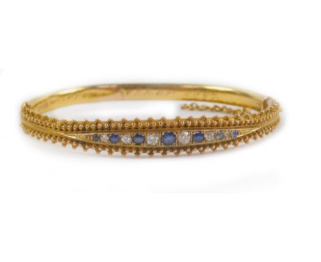 A Victorian 15ct gold sapphire and diamond bangle, channel set on a snap clasp with safety chain as fitted, presentation engr