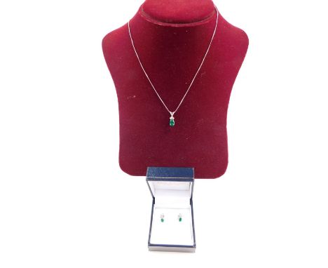 A 9ct white gold emerald and diamond pendant on chain,  and pair of matching earrings, 3g.