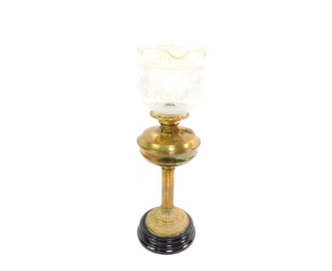 A Duplex brass oil lamp, with a fluted column and embossed foliate base, raised on a black pottery socle, with chimney and et
