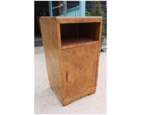 An Art Deco burr walnut bedside cabinet, the top, with step moulding, open recess and hinged cupboard door.