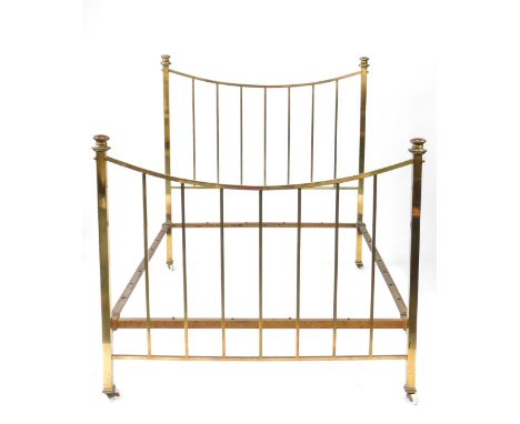 A late Victorian brass bed, with turned finials, upright rails, on ceramic castors, 149cm H, 141cm W.