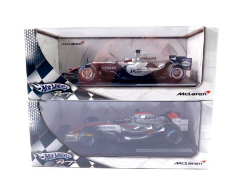 Two Hot Wheels die cast models of McLaren racing cars, Juan Pablo Montoya, MP4-20 and MP4-21, scale 1:18, boxed.