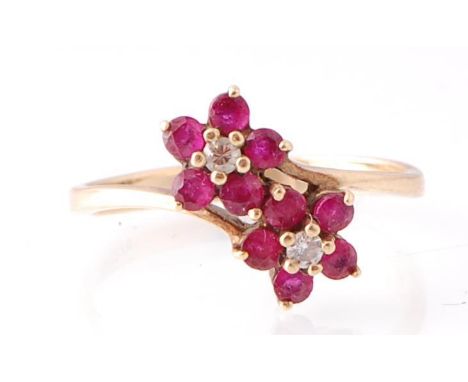 A 9ct gold ruby and diamond double flower head ring. Each flower with ruby petals and diamond centres. Total weight 1.97g / S