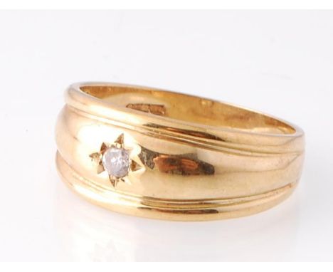 A hallmarked 9ct gold and diamond ring. The ring having a reeded domed face with a star set round brilliant cut diamond. Hall