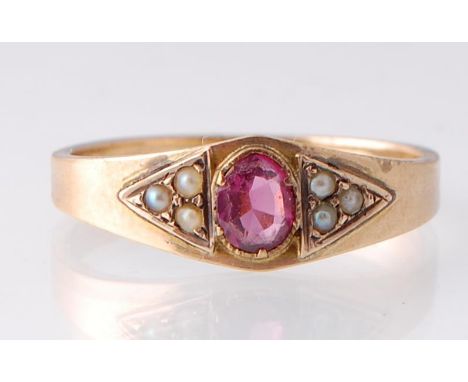 An Art Deco pearl and garnet ring. The ring set with a central garnet flanked by two sets of half pearls. Marked 10ct and spo