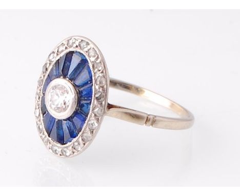A French 18ct gold Art Deco Sapphire and diamond ring. The ring having a central round cut diamond surrounded by a sunburst h