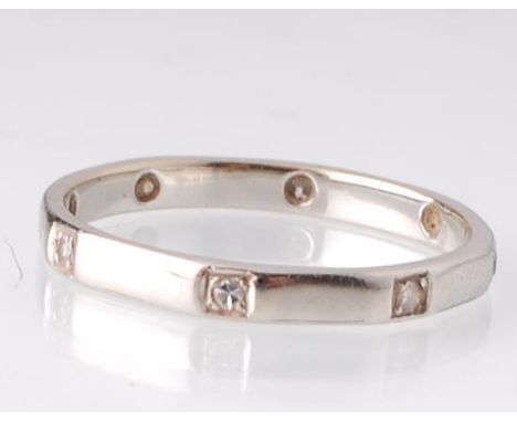 An 18ct white gold eternity ring. The ring being set with 8 single round cut diamonds within an octagonal panel design. Marke