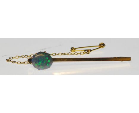 A stunning 9ct gold bar brooch having a single prong set opal cabochon with safety chain and pin to verso. Stamped 9ct. Weigh
