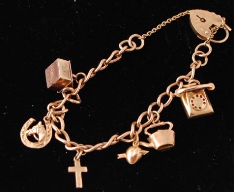 A 9ct gold charm bracelet&nbsp; adorned with 6 charms to include house, telephone, cross, kettle, heart and arrow and horsesh