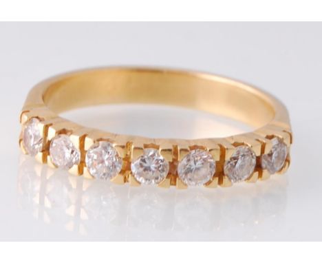 An 18ct gold 7 stone diamond ring. The ring set with 7 round brilliant cut diamonds on a plain shank. Estimated diamond weigh