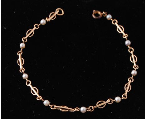 A 9ct gold and pearl ladies bracelet chain uniting with c-clasp having 9 pearls intersected with lozenge shaped links. Measur
