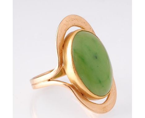 A hallmarked 18ct gold and nephrite jade ring. The ring having a central large bezel set oval nephrite cabochon with elliptic