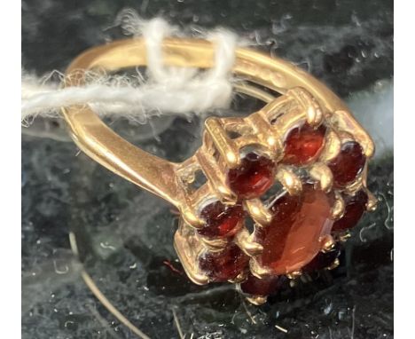 A 9 carat gold garnet set cluster ring of flower head form, size L, 2.9 g
