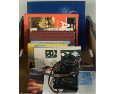 A box of Olympic and Athletic themed items including Sportsmans Bookclub books, programmes and a Zenit camera marked with Rus