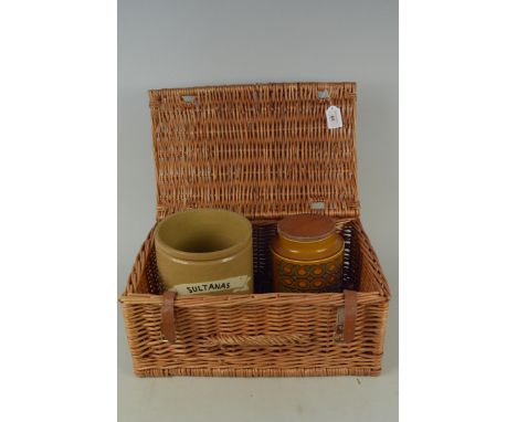 A wicker picnic basket containing a stoneware 'Sultanas' jar, a Hornsea biscuit barrel plus a Hornsea six jar spice rack