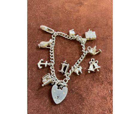 A silver charm bracelet set with several charms, including anchor, typewriter, and watering can, approx. 35.5g.