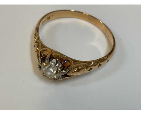 An 18ct yellow gold diamond solitaire ring, the eight claw set stone approx. 0.65cts, with engraved detail to the shoulders, 