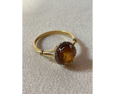 An 18ct yellow gold oval dress ring set with tiny diamonds and central orange oval stone, size V, approx. 4.6g. 