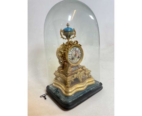 A late 19th century French gilt metal and porcelain mounted eight day mantel clock presented on a stepped plinth with a glass