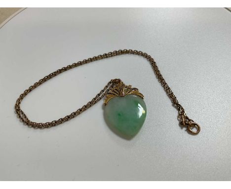 An 18ct yellow gold fine link chain, length 42cm, suspending a heart shaped carved jade yellow metal mounted pendant, weight 