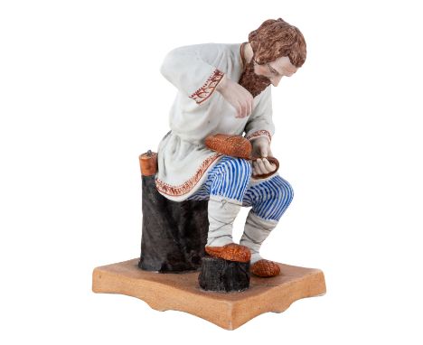 A RUSSIAN PORCELAIN FIGURE OF A BAST SHOE MAKER, POPOV PORCELAIN FACTORY, CIRCA 1850S-1870S realistically modeled, sitting on