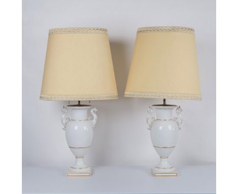 Adorned with griffons on each side with gilt accents throughout. Brass mounts hold pull chain lights. Large fabric shades wit