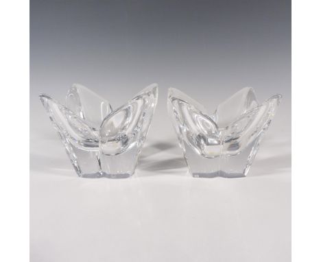 A set of 2 clear votive candle holders in a shaped of a four-petal flower. Orrefors marked on the underside. Issued: c. 1989-