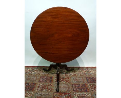 A George III Mahogany Tilt Top Table, the circular top above a turned centre column and quadripartite legs with pad feet, 88 