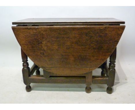 An 18th Century Oak Oval Gate-leg Dining Table, with turned legs and stretchers