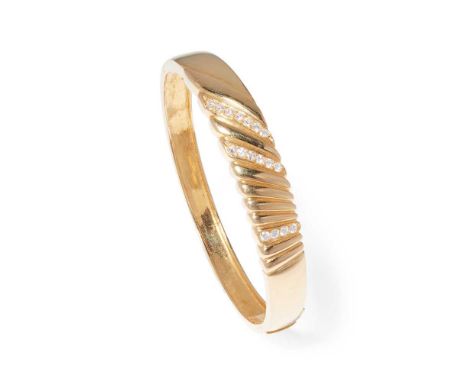 A diamond bangle of hinged design, claw-set with three rows of brilliant-cut diamonds, stamped 750Dimensions:Internal width: 