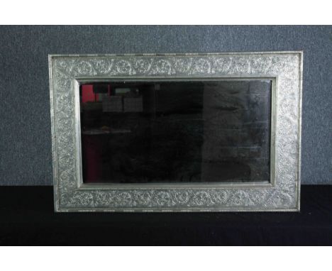 Wall mirror, embossed metal frame. H.62 W.94cm. 