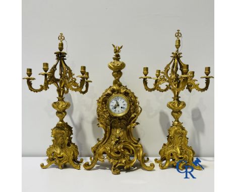 A large 3-piece fire-gilded bronze chimney set in LV style. 19th century. (missing pieces on the candlesticks) Height of cand