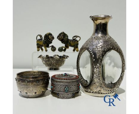A lot with various silver objects and a pair of Buddhist enamelled copper lions.A carafe with a frame in sterling silver, mad