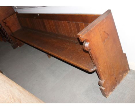 A carved oak pew with trefoil panel ends, 120" long