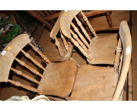 A set of four Windsor spindle back dining chairs with elm panel seats, on turned and stretchered supports