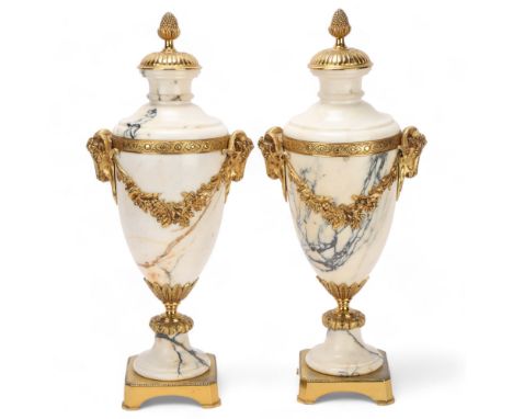 Pair of Calacatta marble and ormolu ornamental urns, probably late 19th century, with relief cast ram's head handles on gilt-