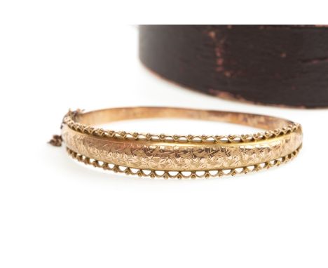 NINE CARAT GOLD BANGLE, with engraved decoration and scalloped border, personal inscription to interior dated 1906, 8.3g, in 