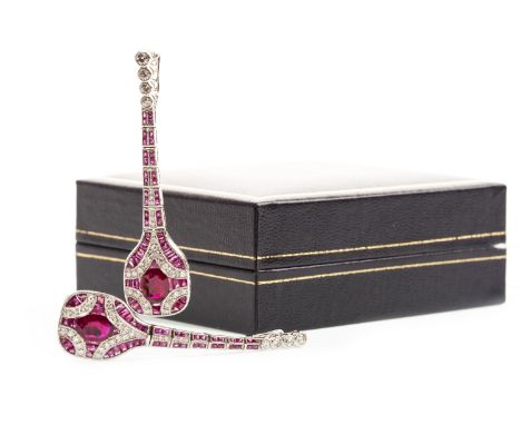 PAIR OF RUBY AND DIAMOND EARRINGS, each set with a central oval ruby flanked by round brilliant cut diamonds and calibre cut 