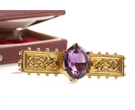 VICTORIAN GEM SET BAR BROOCH, the central oval purple gem with Celtic decoration to either side, bordered by spherical termin