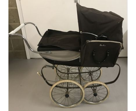 A vintage Silver Cross dolls pram  in brown and cream colourway. Complete with cover and nappy changing bag.