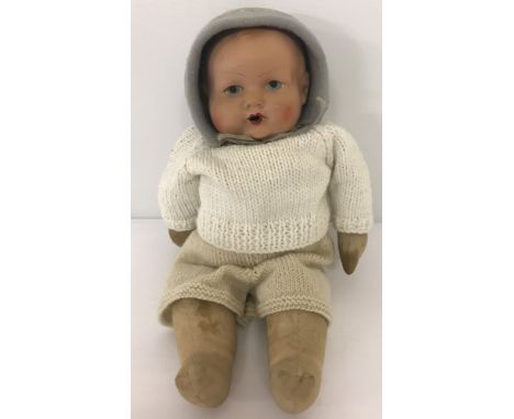 A vintage soft bodied composite head baby doll.  With painted eyes lips and cheeks. Open mouth.