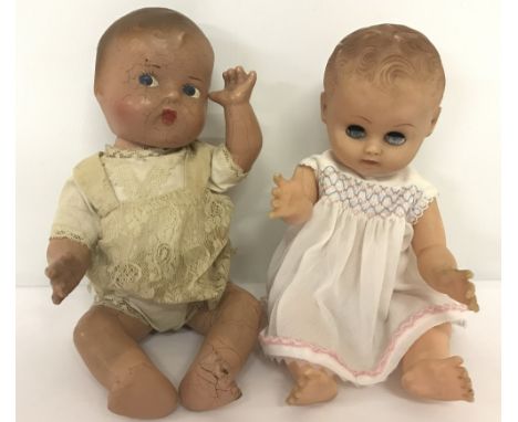 A vintage composition doll with painted face together with a vintage vinyl Rosebud doll. Composition doll has cracking to fac
